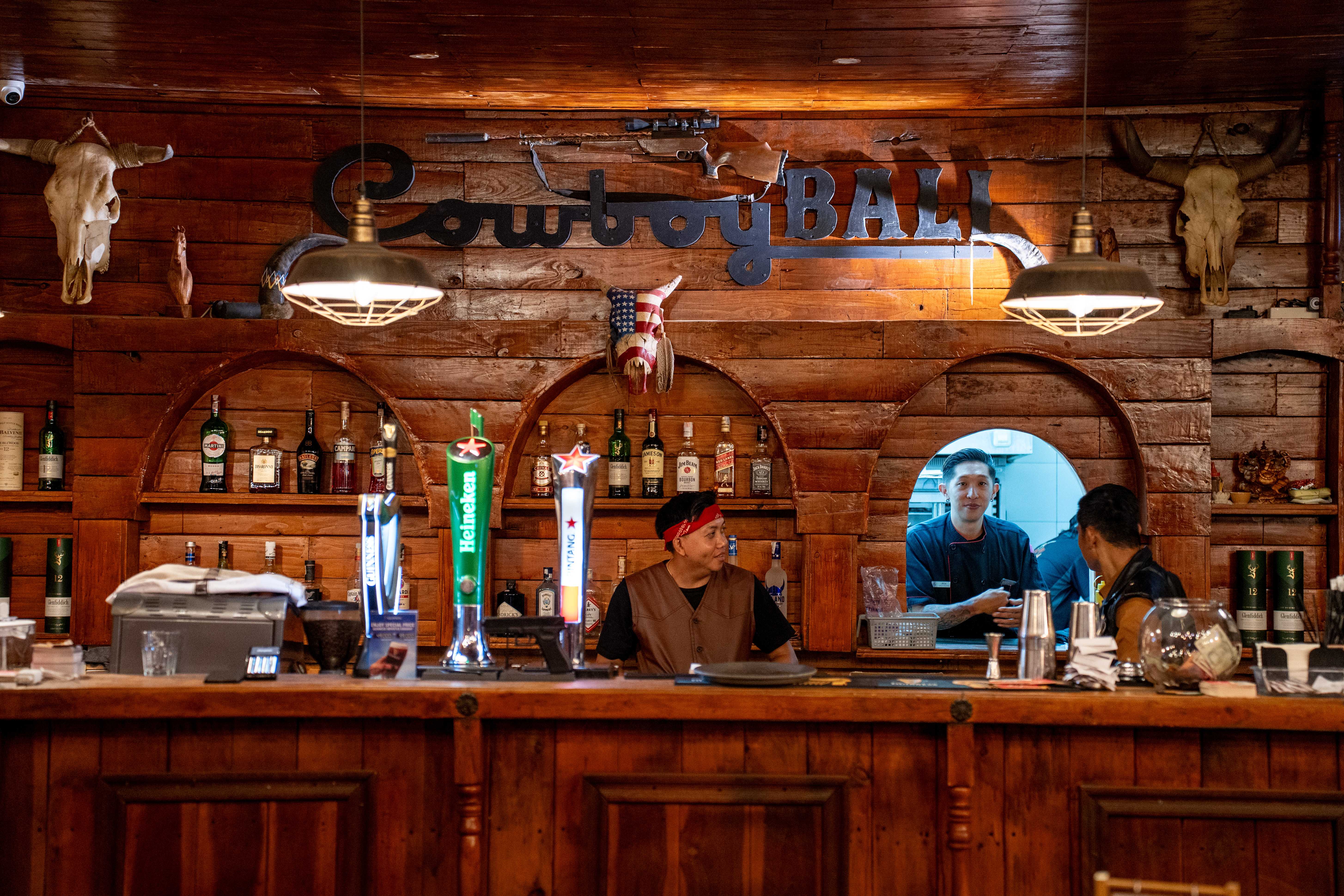 Cowboy Bali bar with metal signage and rustic wood decor