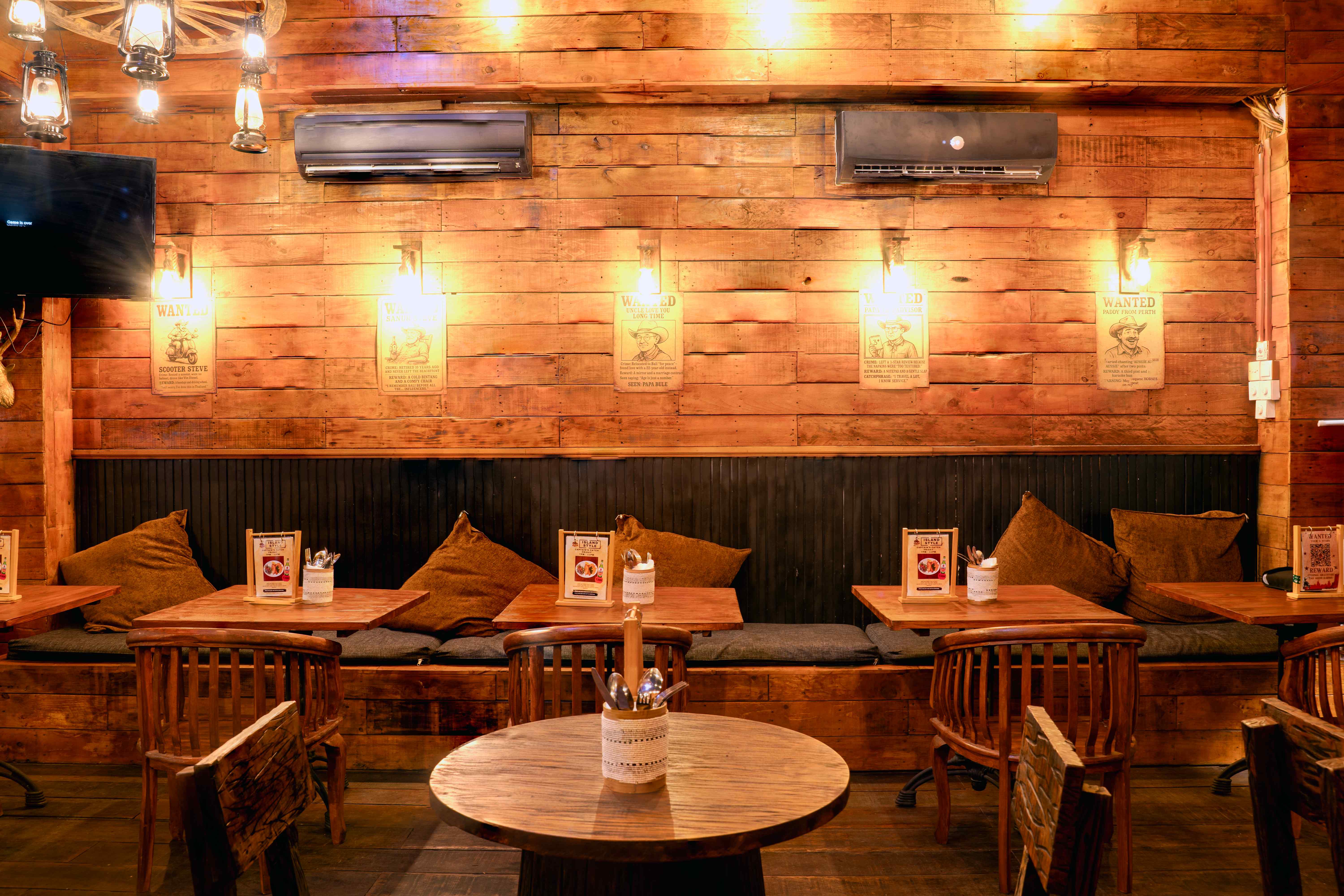 Cozy booth seating with WANTED posters and lantern lighting